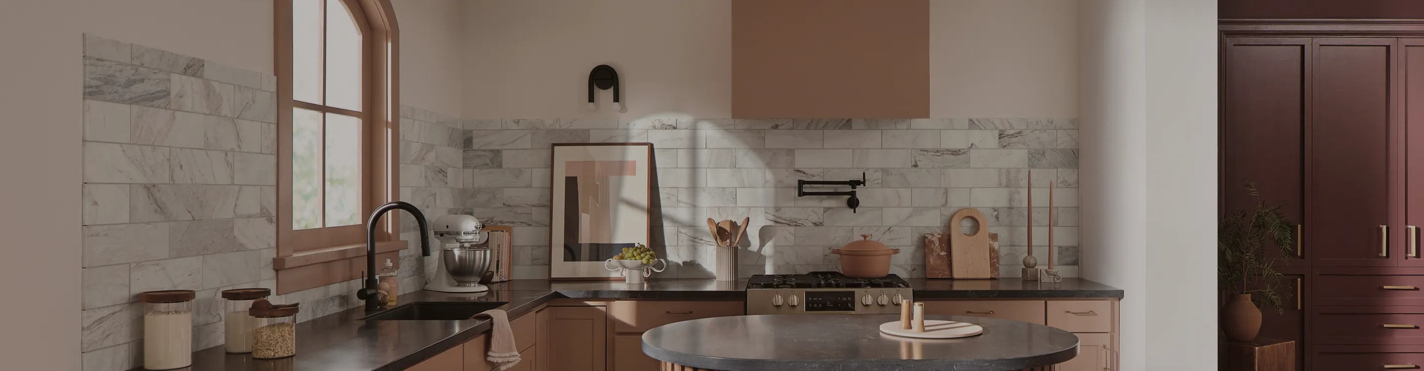 Gray and white tile backsplash in a kitchen with black countertops