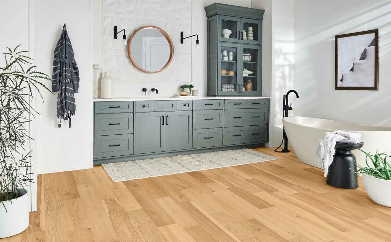 Hardwood Flooring in Bathroom with Tub, Sink, Mirror, and Cabinets